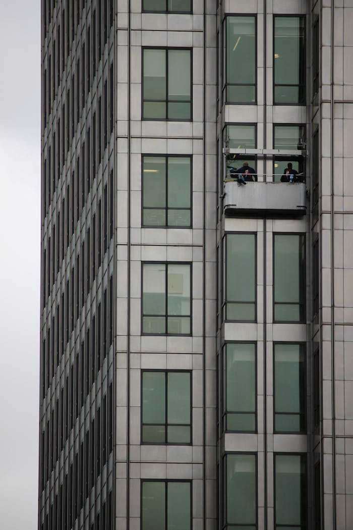A modern skyscraper in London with a window cleaning platform on a cloudy day.